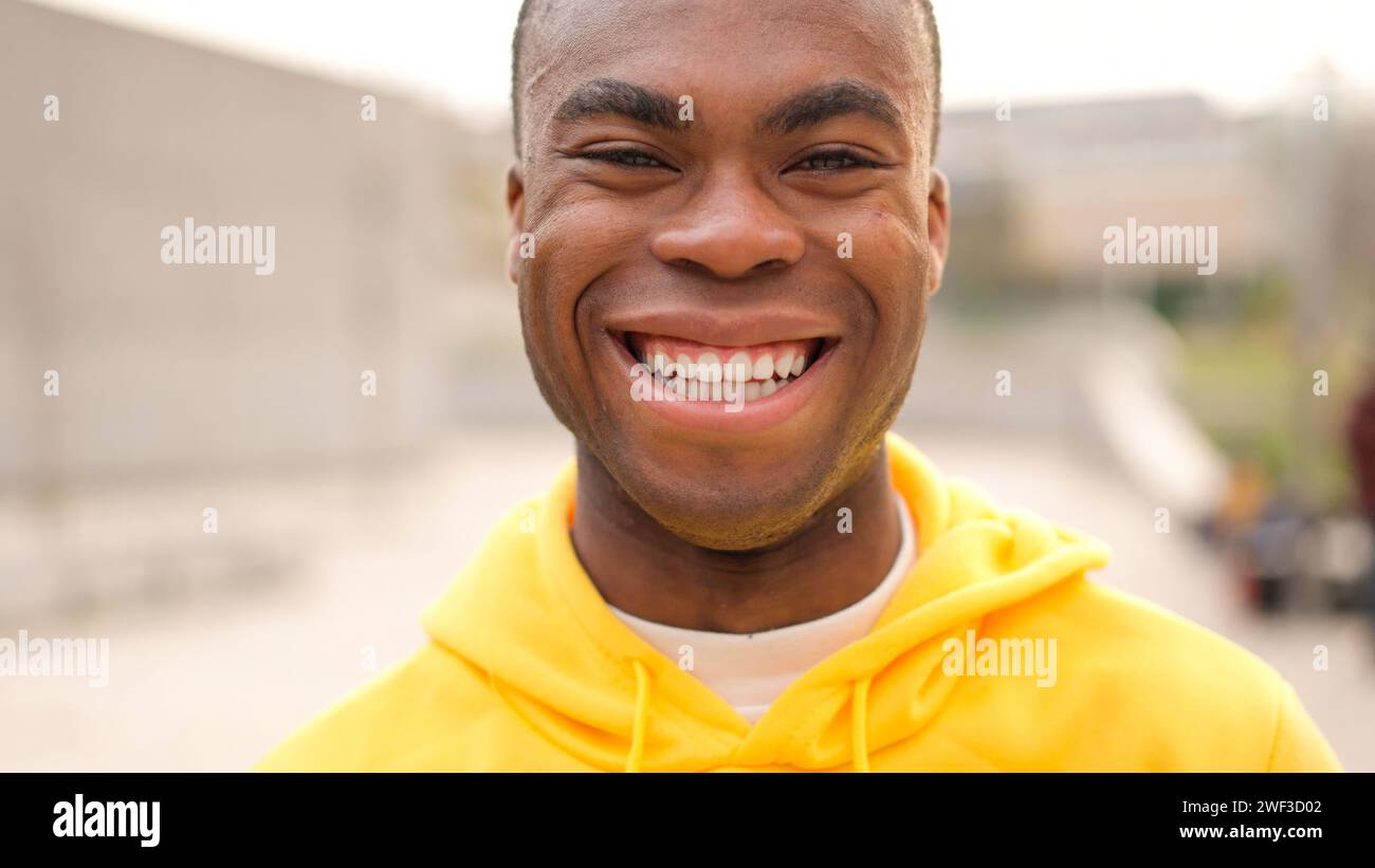 Un jeune homme africain debout et riant Banque D'Images