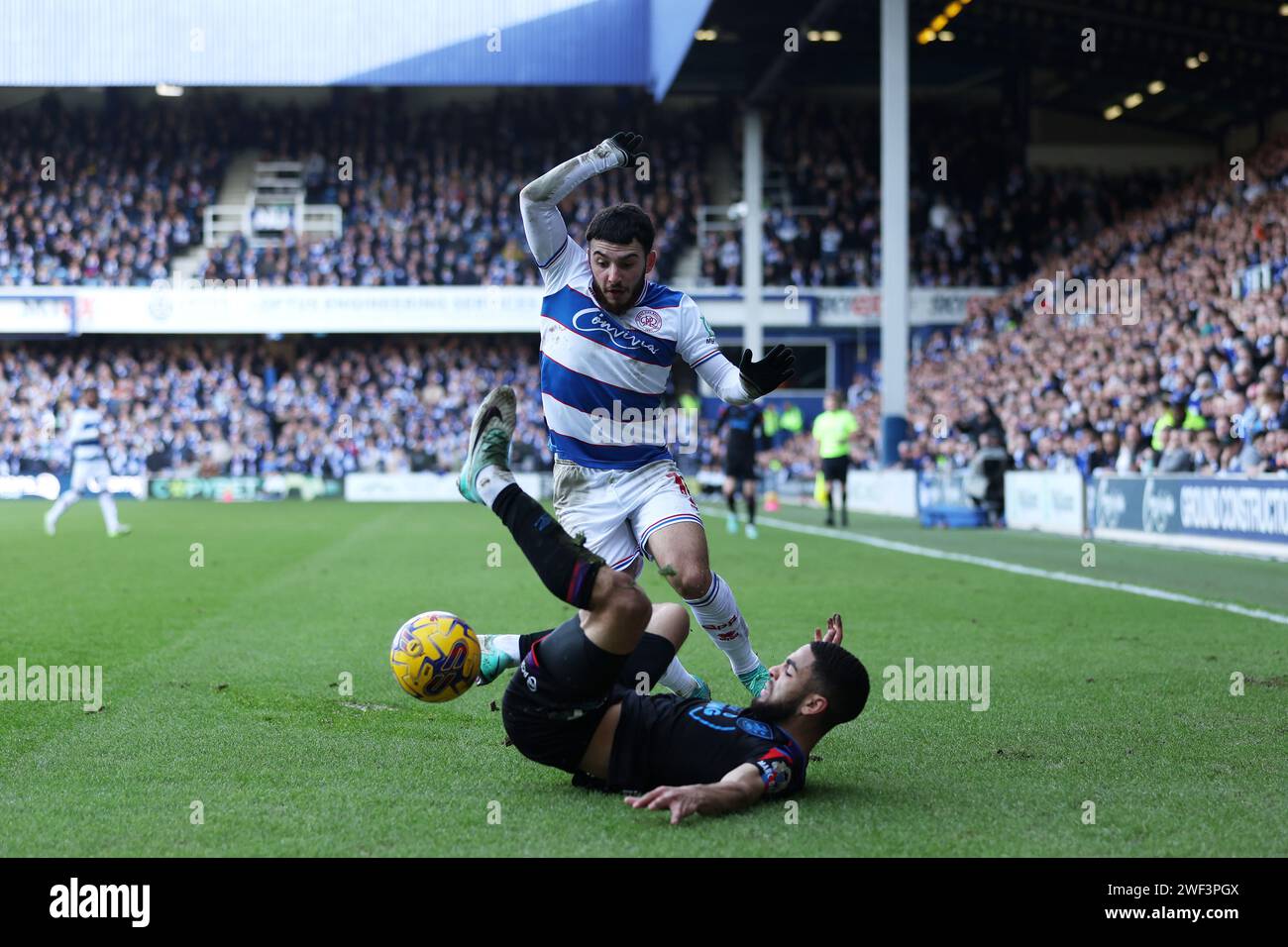 Ilias chair des Queens Park Rangers (en haut) et Brodie Spencer de Huddersfield Town se battent pour le ballon lors du match de championnat Sky Bet au MATRADE Loftus Road Stadium, Londres. Date de la photo : dimanche 28 janvier 2024. Banque D'Images