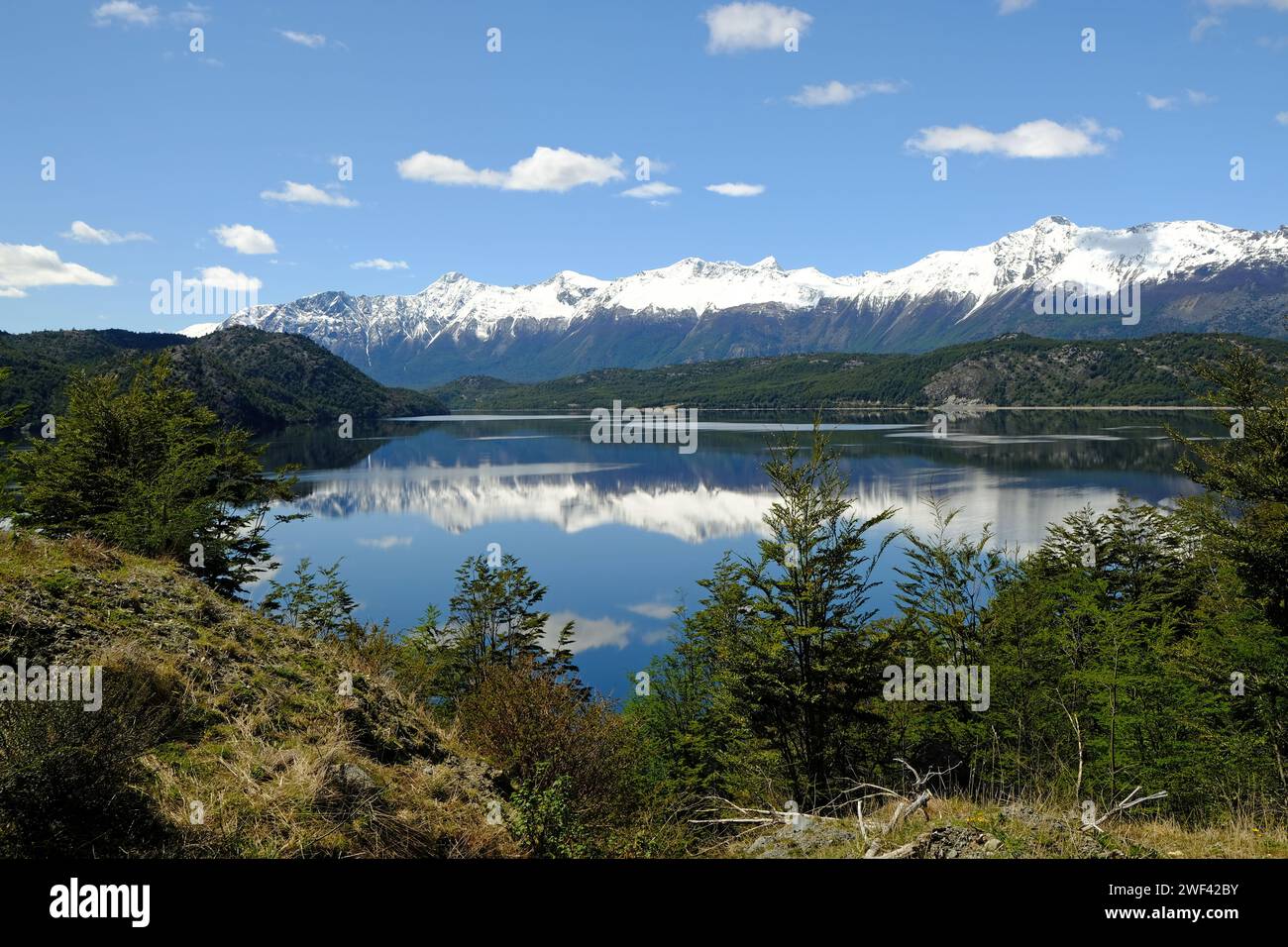 Les montagnes enneigées du Chili patagonien se reflètent dans les eaux tranquilles du Lago Cisnes près de Villa O'Higgins sur la Carretera Austral. Banque D'Images