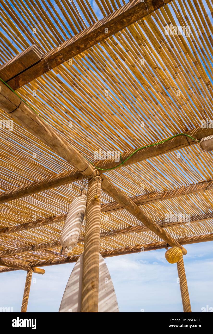 Auvent en bois en bambou fournissant de l'ombre pour les clients dans un café et restaurant de bord de plage sur l'île canaries de Fuerteventura. Banque D'Images