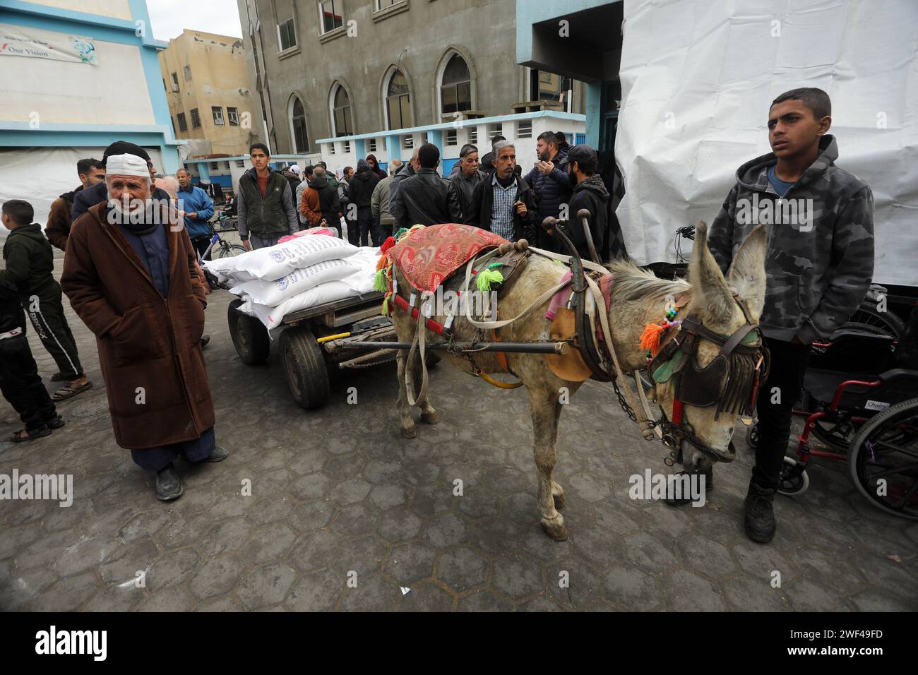 Les Palestiniens déplacés reçoivent des sacs de farine à l’école de l’Office de secours et de travaux des Nations Unies pour les réfugiés de Palestine (UNRWA) à Rafah, dans le Sud de la bande de Gaza, le dimanche 28 janvier 2024, alors que les combats se poursuivent entre Israël et les combattants palestiniens. Israël a allégué que plusieurs membres du personnel de l'UNRWA étaient impliqués dans l'attaque du Hamas en octobre 7, ce qui a conduit certains pays donateurs clés à suspendre le financement et l'agence à licencier plusieurs membres du personnel à cause des revendications, dans une rangée entre Israël et l'UNRWA un jour après la décision de la Cour internationale de Justice de l'ONU. Photo par Ismael Mohamad/UPI. Banque D'Images