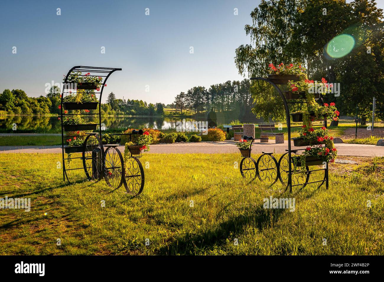 Modèle décoratif de vieux vélo équipé de paniers de fleurs sur fond de lac . Vélos avec paniers de fleurs dans le vieux Smiltene Banque D'Images