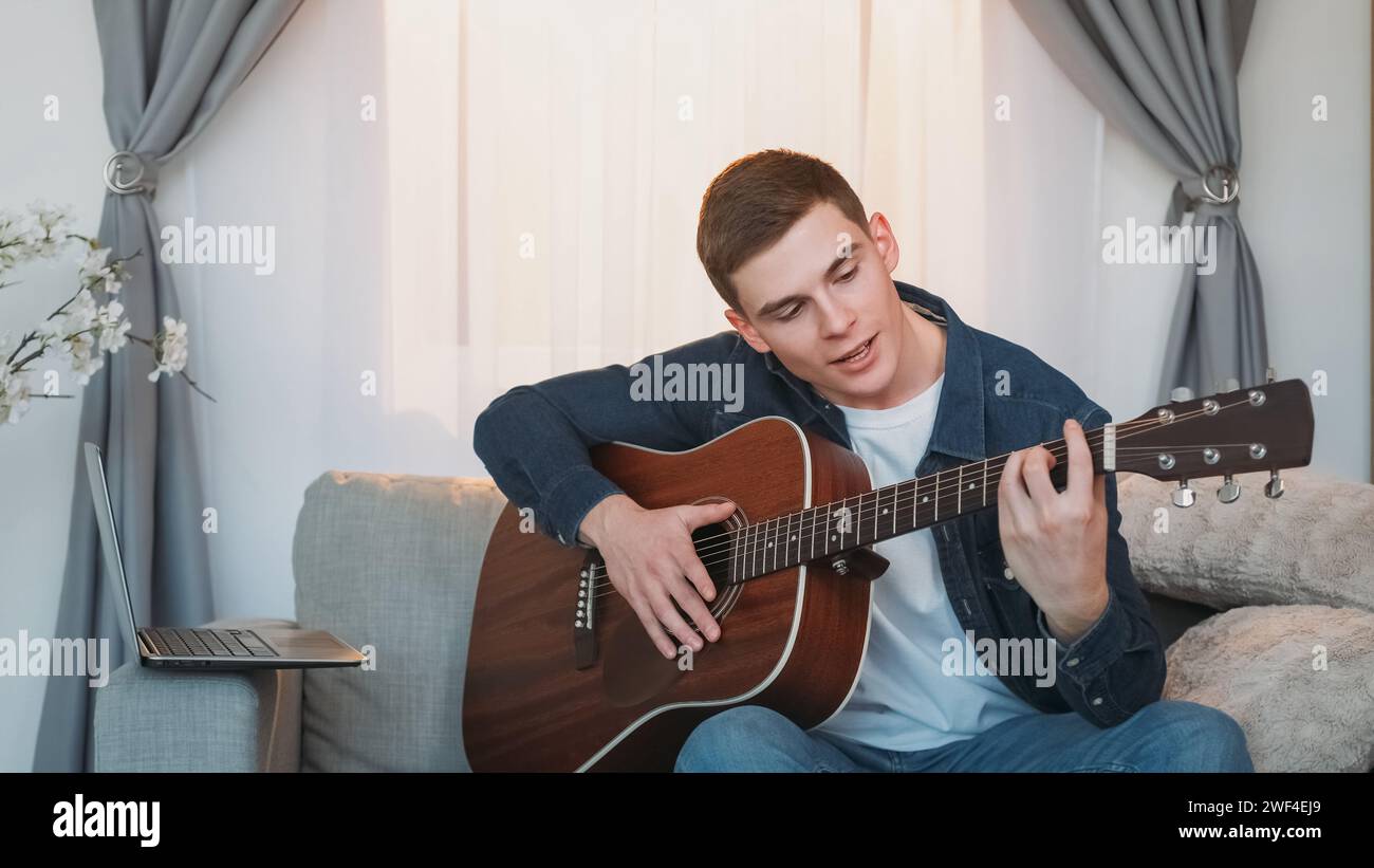 Cours de musique en ligne leçon de guitare homme ordinateur portable maison Banque D'Images