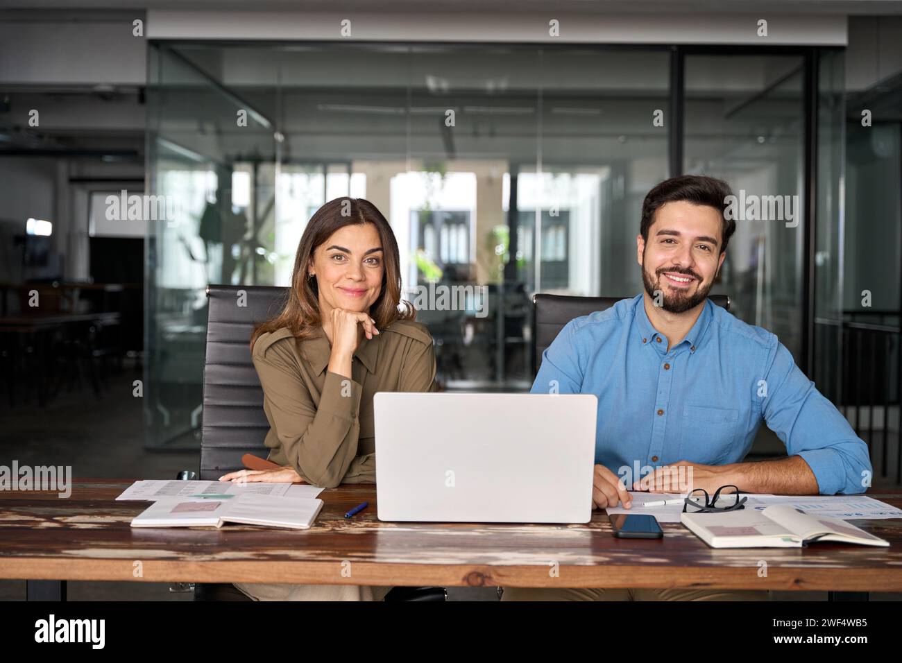 Heureux homme d'affaires professionnel et femme assis dans le bureau avec ordinateur portable. Portrait Banque D'Images