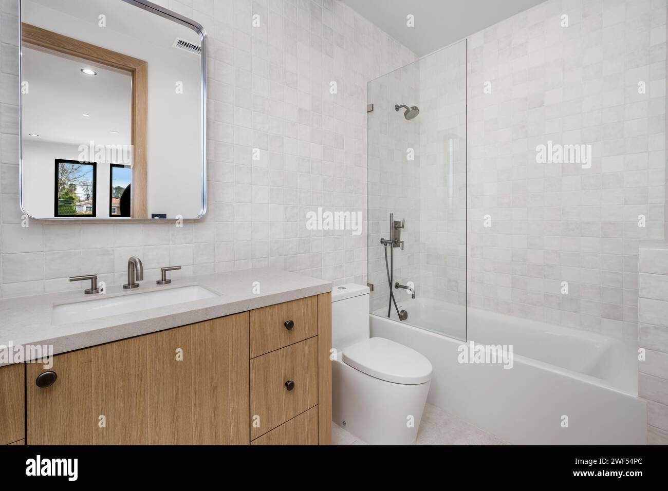 toilettes blanches et baignoire dans une salle de bains avec fenêtre Banque D'Images