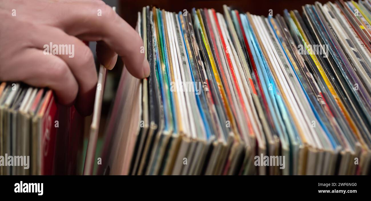 Gros plan de la main d'un homme regardant des disques vinyles dans un magasin de musique. Banque D'Images