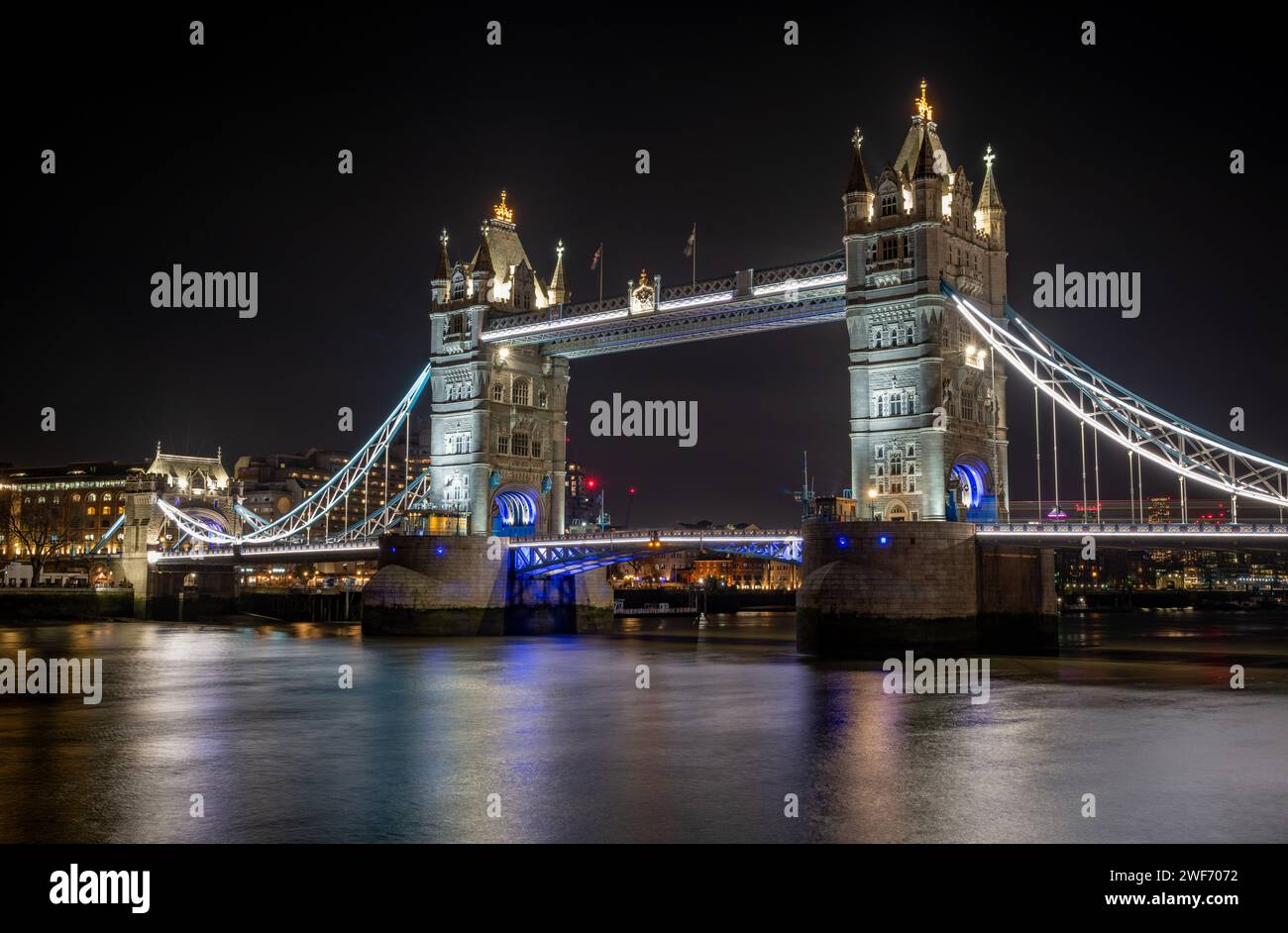 La nuit, vue longue exposition Tower Bridge depuis le Queens Walk sur la rive sud de la Tamise montrant des lumières colorées et une belle lumière Banque D'Images