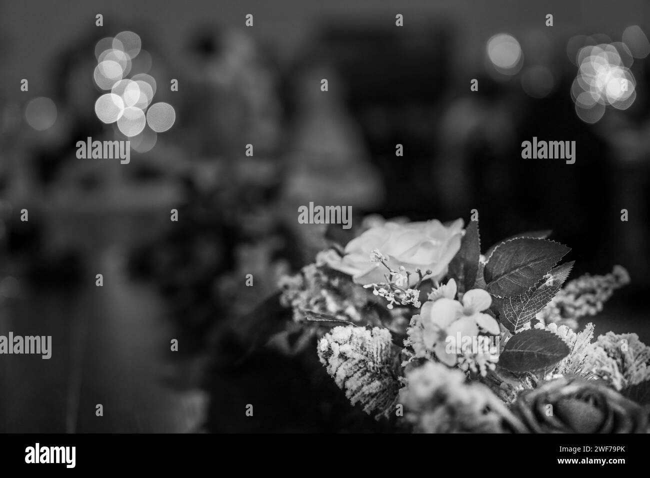 Une photo en niveaux de gris d'une pièce maîtresse de mariage florale avec un gel délicat et un éclairage bokeh doux ajoute un air d'élégance classique Banque D'Images