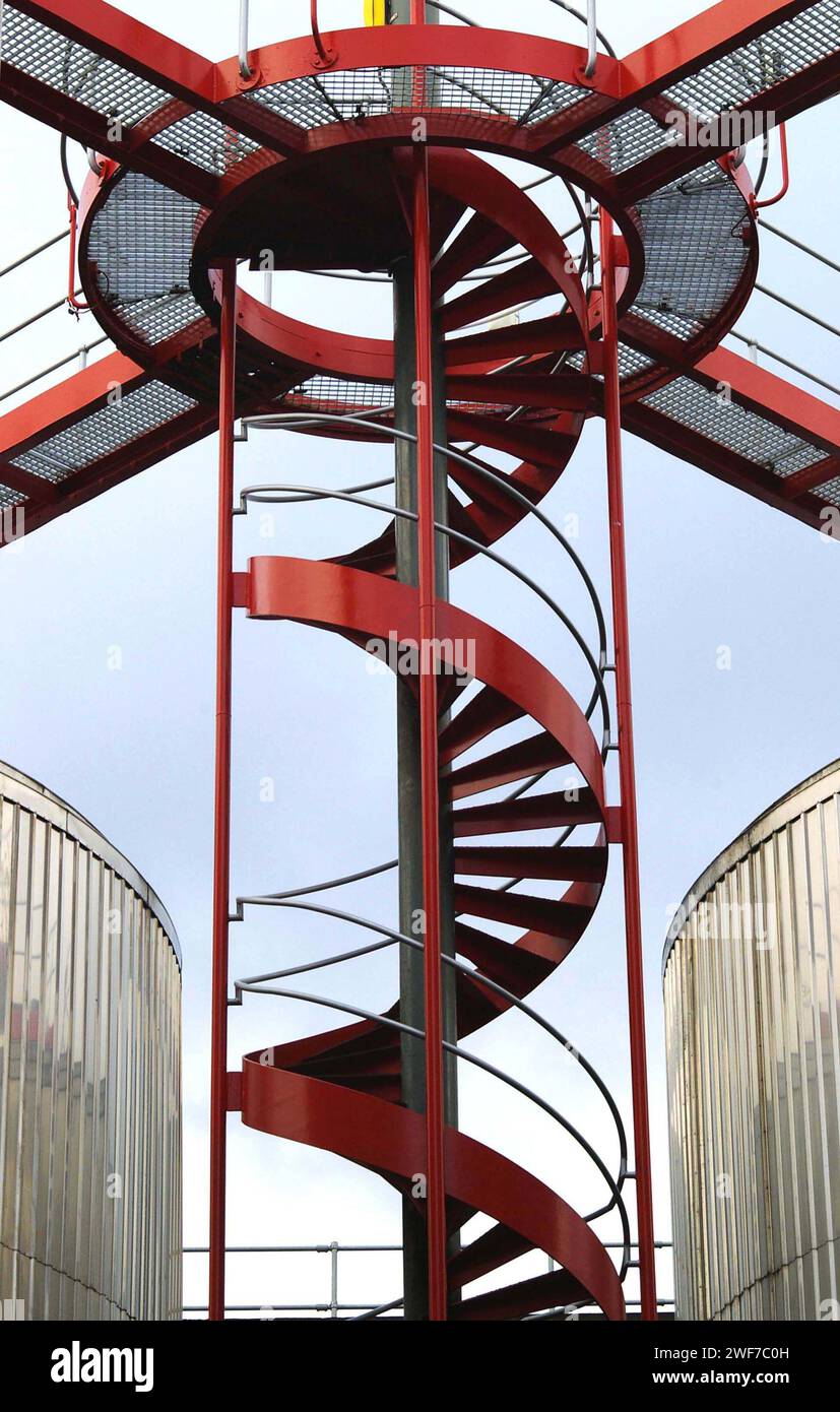 Escalier en colimaçon rouge et plate-forme d'inspection au-dessus des cuves de stockage, Carlsberg Brewery, Northampton, Royaume-Uni Banque D'Images