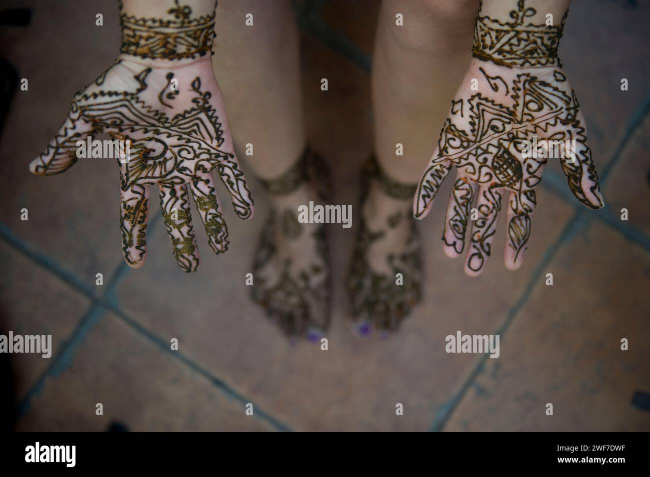 Une femme laisse sécher son tatouage au henné sur ses mains et ses pieds. Banque D'Images