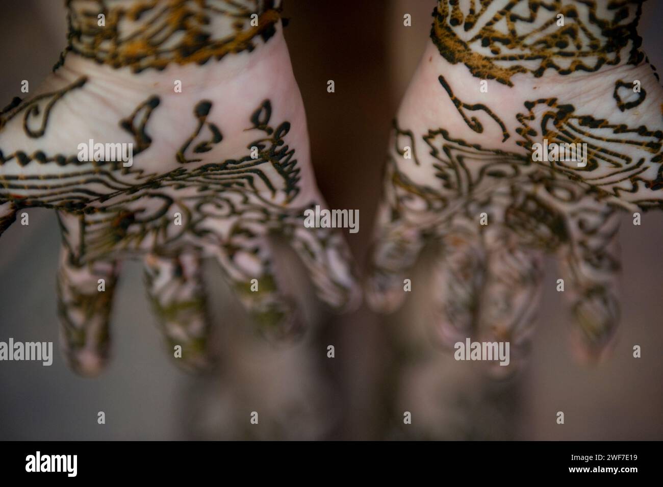Une femme laisse sécher son tatouage au henné sur ses mains et ses pieds. Banque D'Images