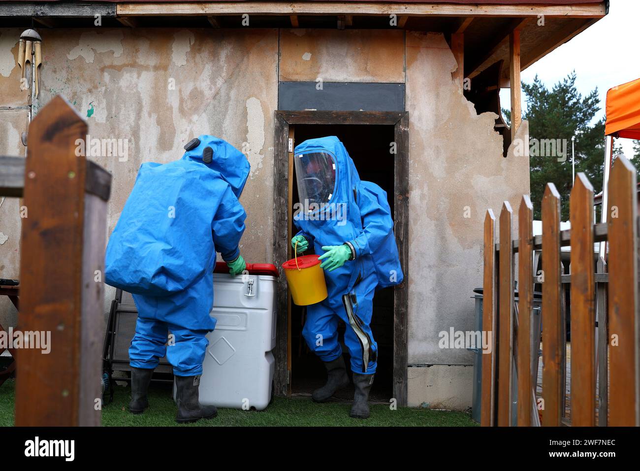 Les gens portent un équipement de protection individuelle (EPI) bleu avec masque à gaz pour la protection contre la pollution de l'air et les risques biologiques. Banque D'Images