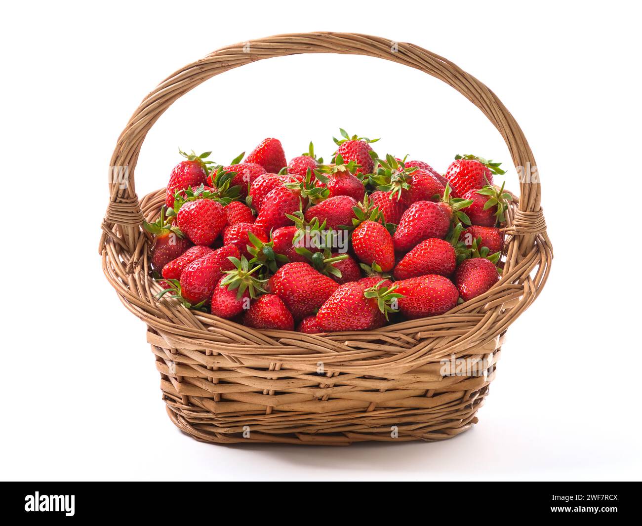 Panier vintage plein de fraises mûres fraîchement récoltées, rouge vif, fruits sains et délicieux, isolé sur blanc Banque D'Images