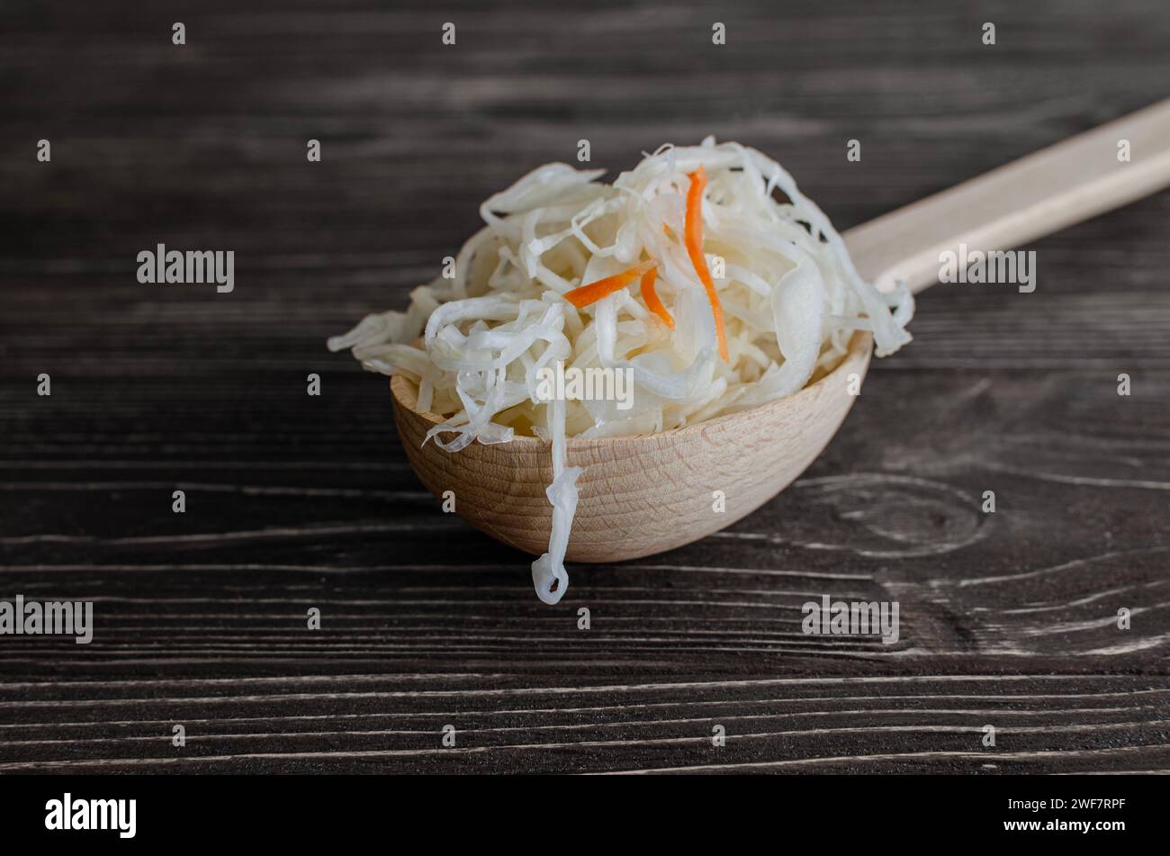 Choucroute dans une cuillère en bois sur une base en bois brun Banque D'Images