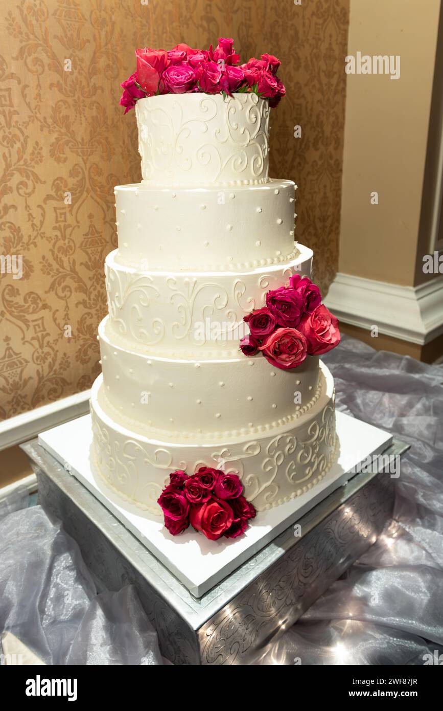 Un beau gâteau de mariage orné de roses délicates Banque D'Images