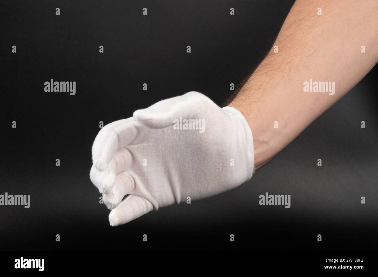 Main dans le tissu blanc geste de prise de gant pose isolée sur fond noir Banque D'Images