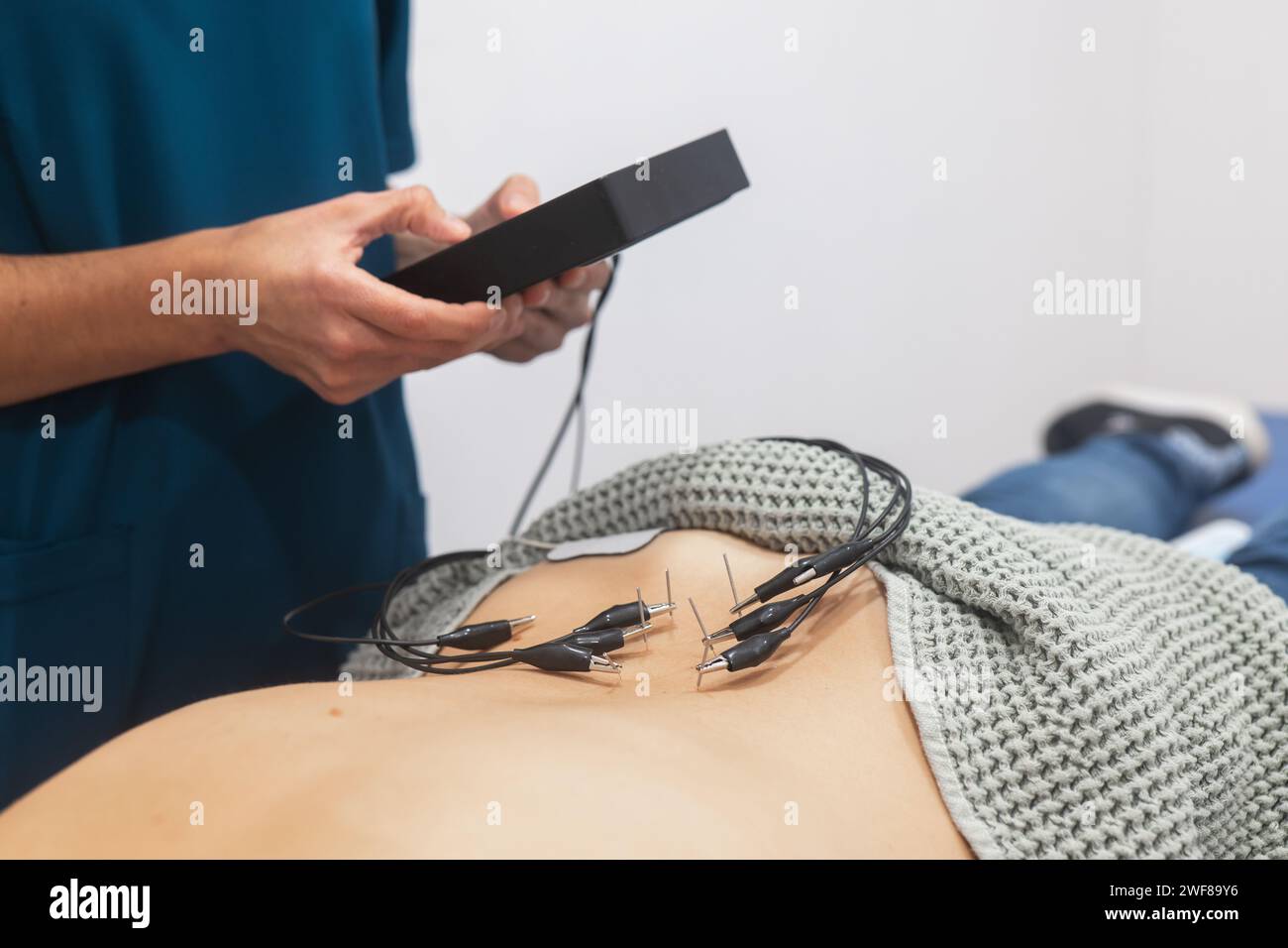 Gros plan d'un professionnel de la santé fixant des électrodes ECG sur le thorax d'un patient pour un test cardiovasculaire Banque D'Images