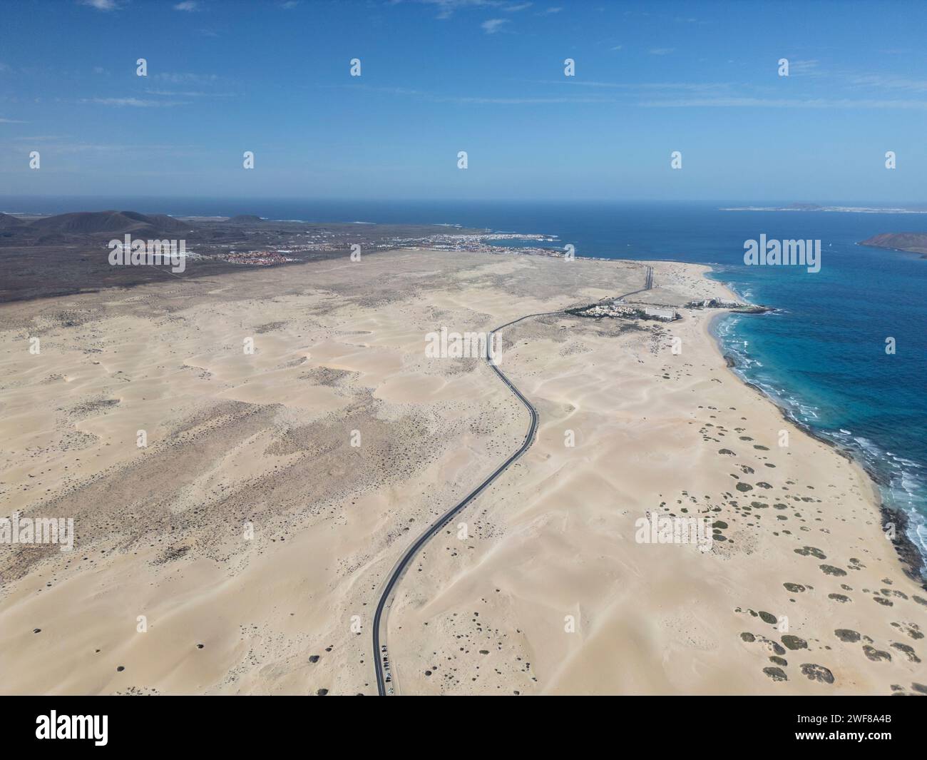 Vue de dessus de la vue expansive d'une route serpentant à travers Corralejo Dunes sur fond d'océan et de ciel clair à Fuerteventura Banque D'Images