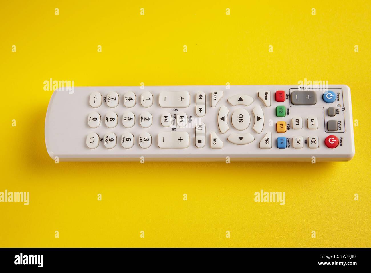 Une télécommande TV Box en position horizontale sur fond jaune Banque D'Images