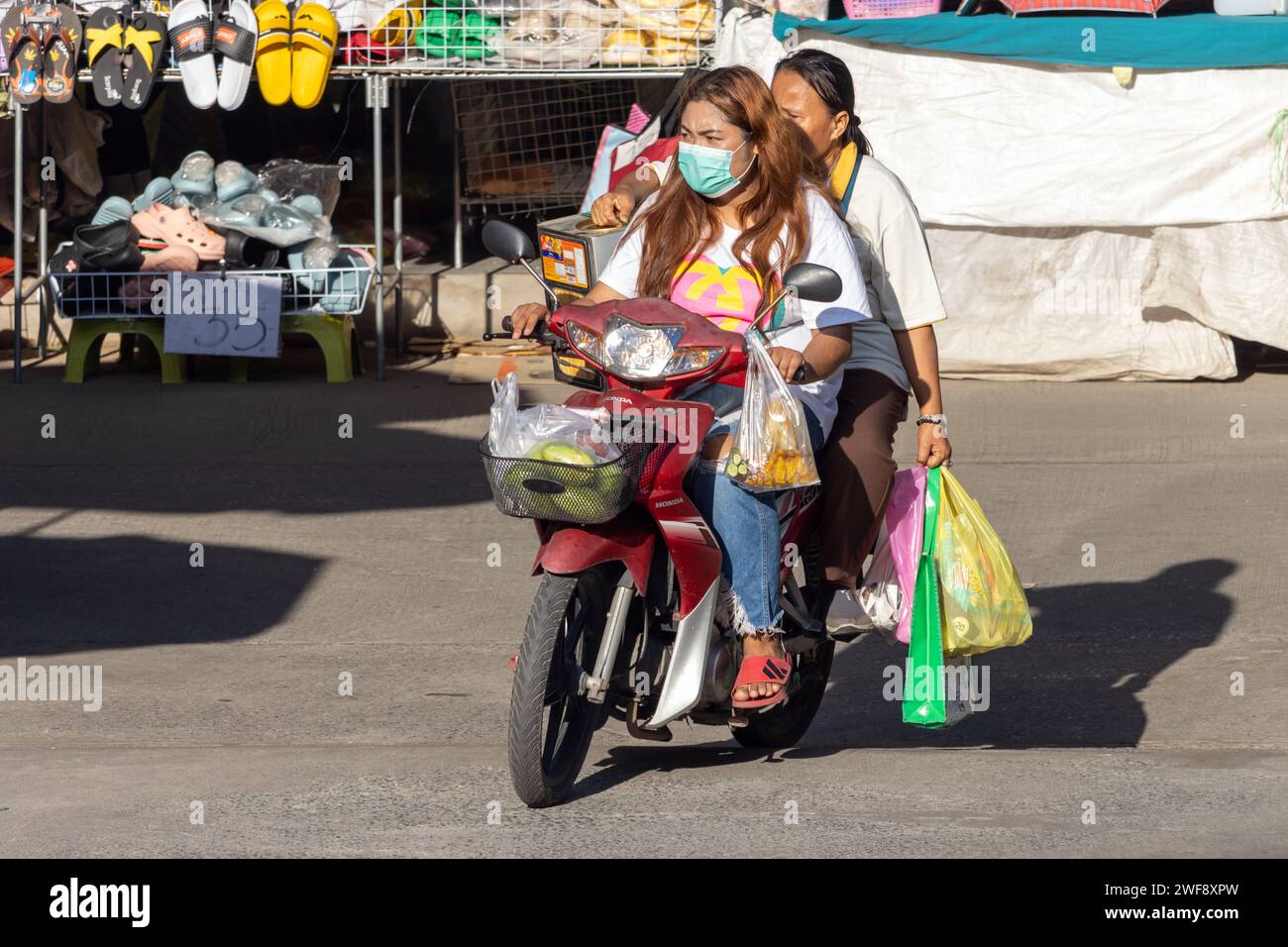 SAMUT PRAKAN, THAÏLANDE, décembre 07 2023, deux femmes conduisent une moto avec des achats sur le marché Banque D'Images