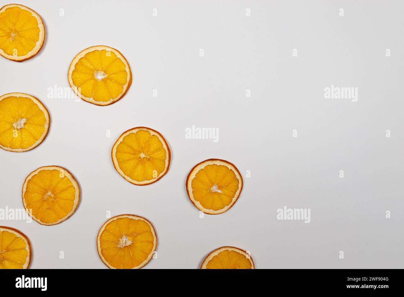 Tranches d'orange séchées sur fond blanc. Composition de Noël, nouvel an, concept d'hiver. Vue de dessus, pose à plat, espace de copie. Banque D'Images