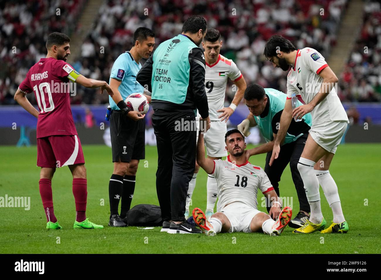 Palestine's Ameed Mahajneh is attended by paramedics after he collided with United Arab Emirates' Yahia Nader during the Asian Cup round of 16 soccer match between Qatar and Palestine at Al Bayt Stadium in Al Khor, Qatar, Monday, Jan. 29, 2024. (AP Photo/Aijaz Rahi) Banque D'Images