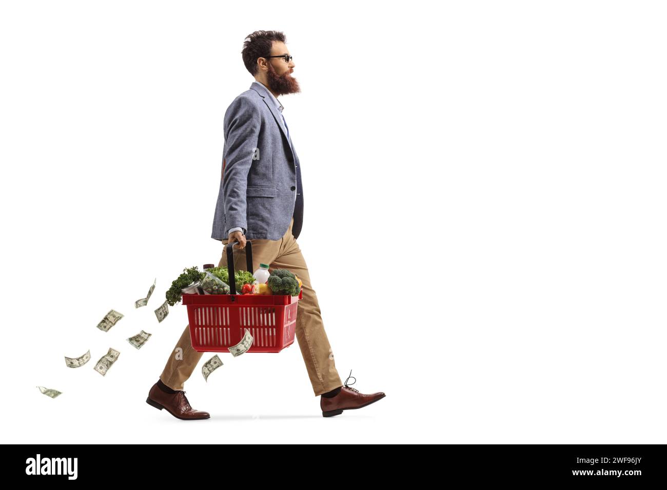 Photo de profil pleine longueur d'un homme marchant avec un panier et perdant de l'argent isolé sur fond blanc Banque D'Images