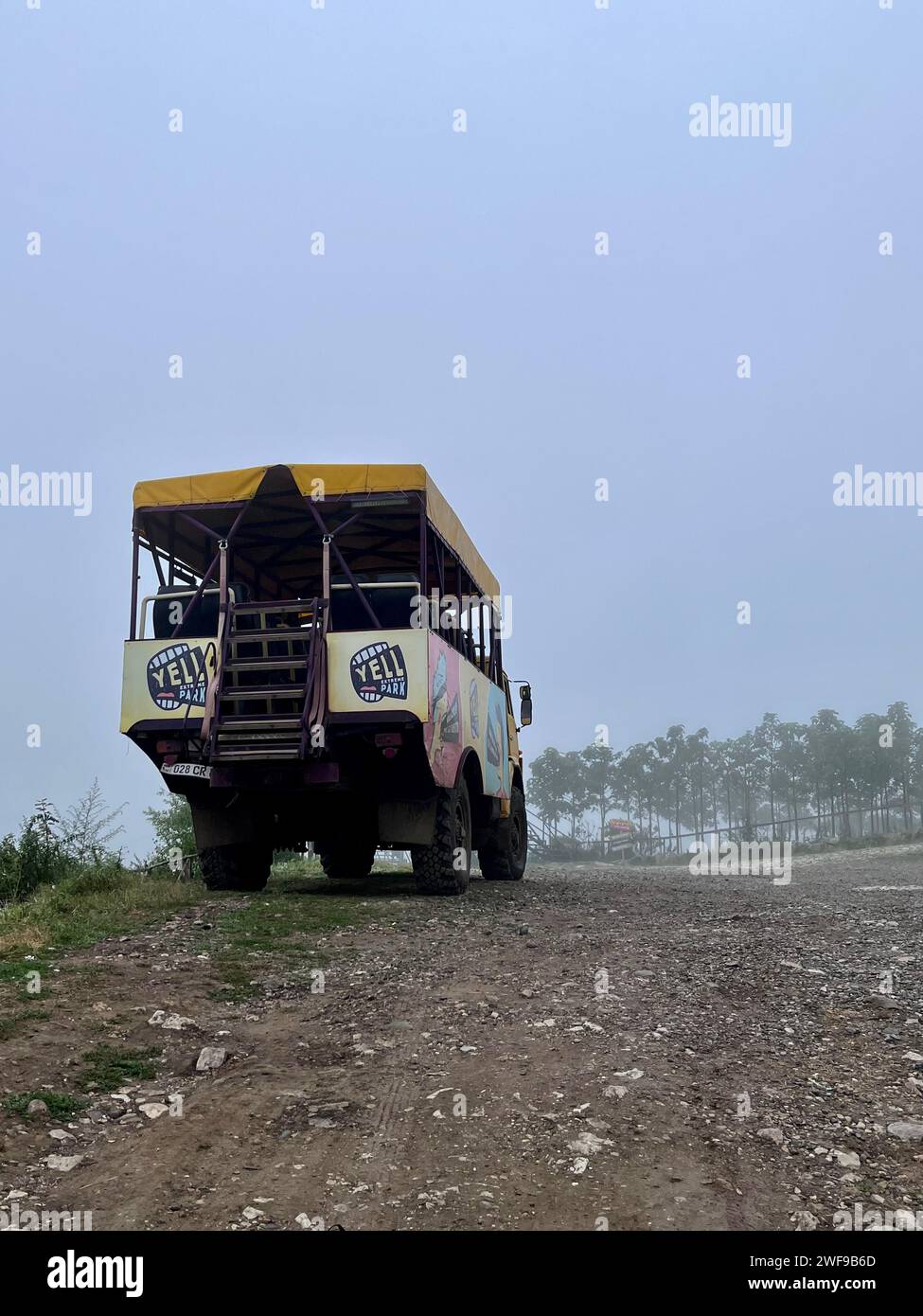 Camion jaune vintage garé sur la route brumeuse Banque D'Images
