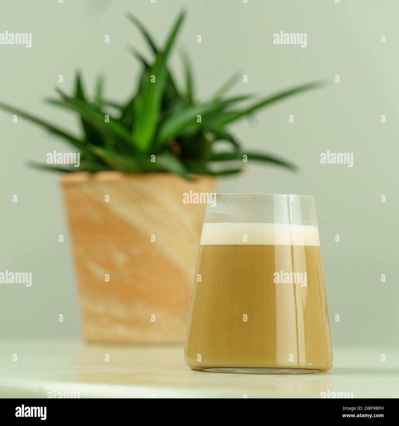 Café Latte spécial dans un verre transparent sur fond blanc - Shot professionnel à angle latéral pour menus et contenu santé Banque D'Images