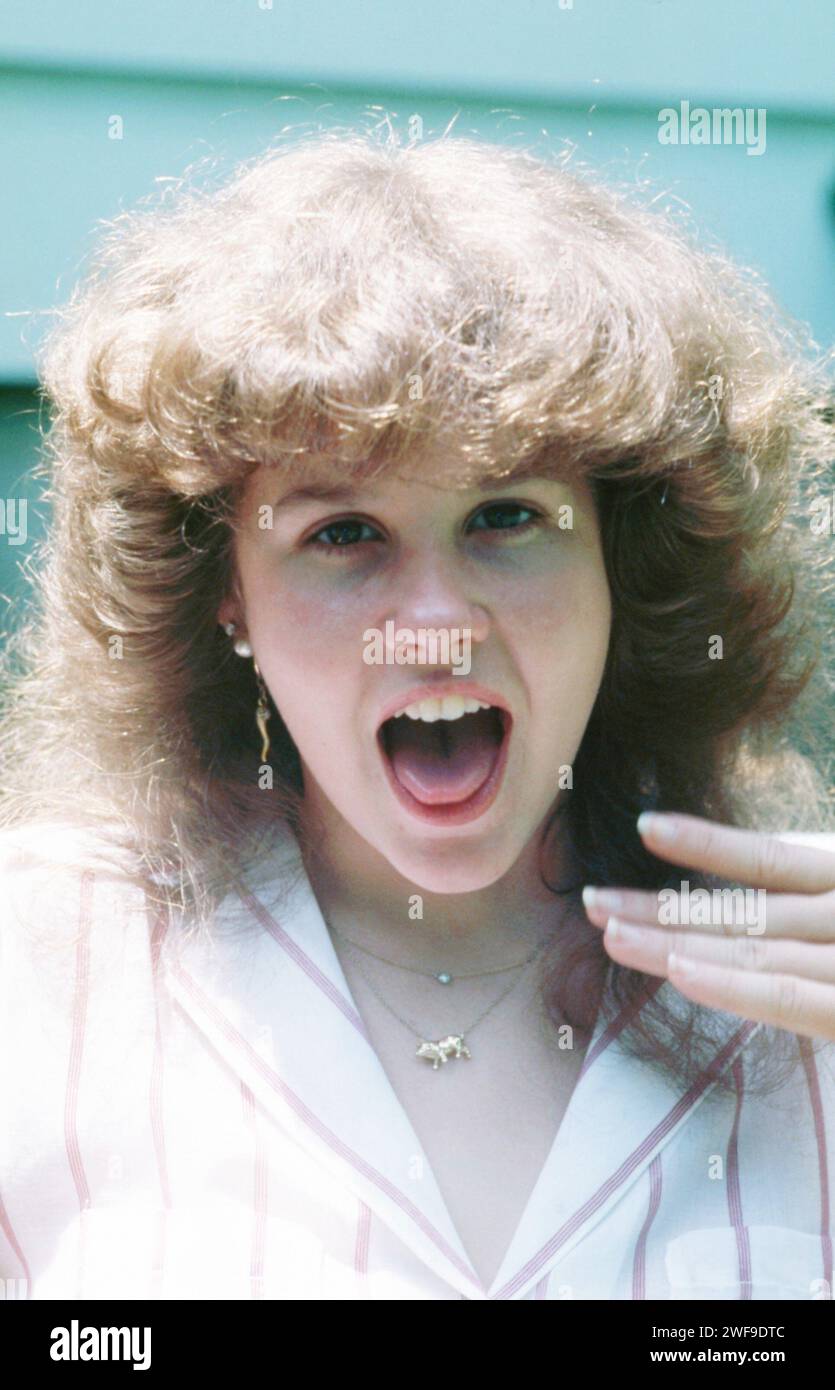 Linda Blair est une actrice américaine, connue pour son travail dans le genre de l'horreur, vue ici avec la bouche grande ouverte montrant sa langue, vêtue d'un chemisier rayé rose et blanc et d'un collier doré, cheveux vers le bas et bouclés, années 1970 Photo : Collection Oscar Abolafia/Everett (lindablair019) Banque D'Images