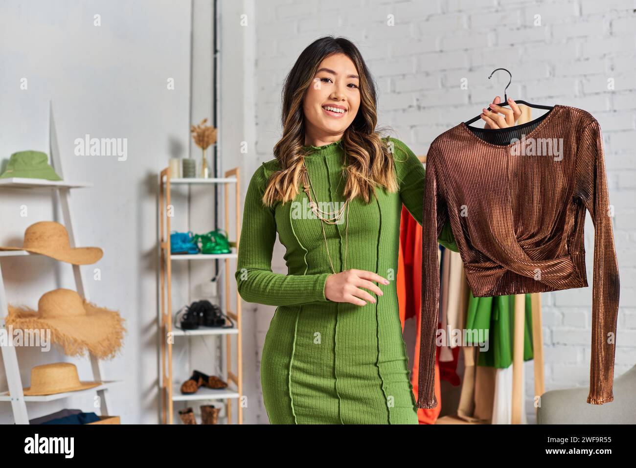 styliste personnel asiatique avec une élégante blouse sur mesure regardant la caméra dans son propre atelier, petite entreprise Banque D'Images