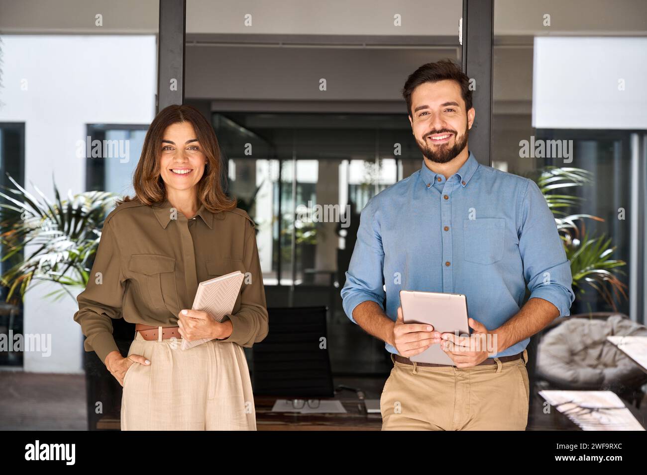 Deux partenaires commerciaux cadres debout dans le bureau regardant l'appareil photo, portrait. Banque D'Images