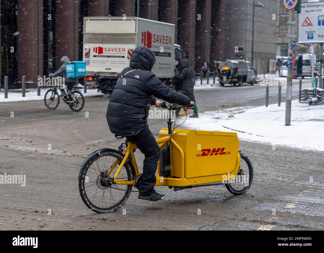 Hiver à Francfort, transporteur à vélo DHL, service de livraison Wolt pour la nourriture, l'épicerie, dans le quartier bancaire, Hesse, Allemagne Banque D'Images