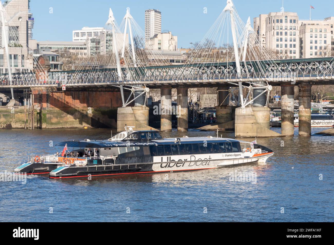 Un bateau Uber, service de bus fluvial par Thames Clippers, approchant Hungerford Bridge, Londres, Angleterre, Royaume-Uni Banque D'Images