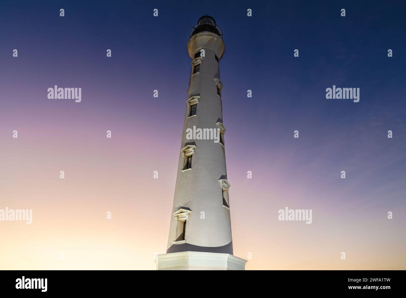 Célèbre phare de Californie, sur l'île d'Aruba. Ciel crépusculaire coloré derrière, allant du jaune au violet. Banque D'Images