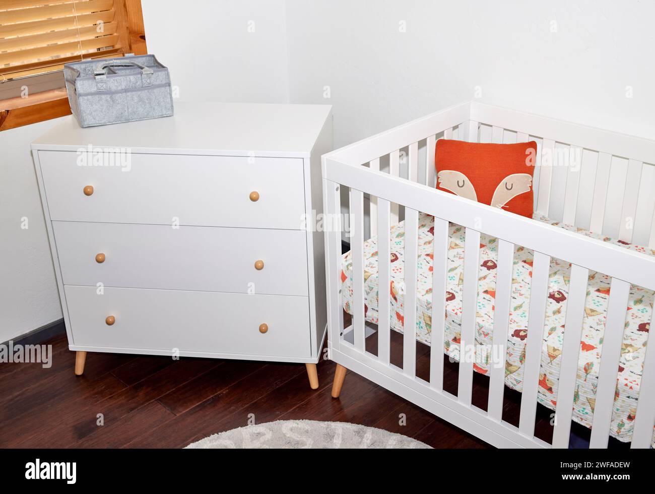 Un ensemble de meubles pour bébé d'une commode blanche et d'un lit d'enfant Banque D'Images