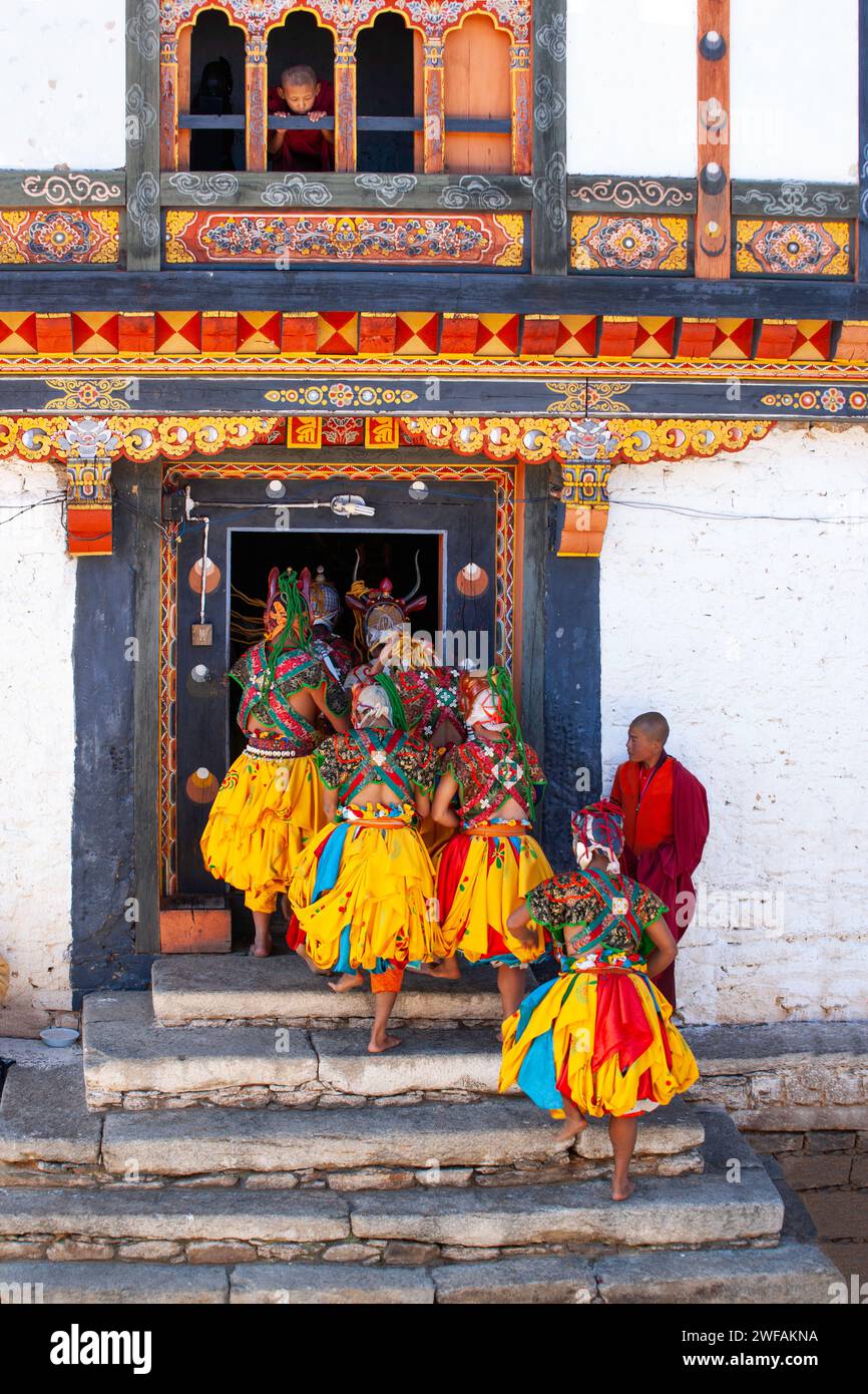 Un garçon regardant par une fenêtre ouverte regarde des moines masqués entrer dans le temple après avoir dansé pour les habitants au festival annuel de Prakhar Banque D'Images