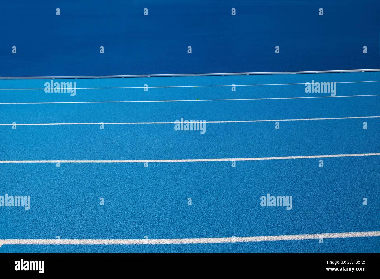 Les pistes olympiques bleues avec des bandes blanches, un fond vide adapté à l'espace de copie, représentent le concept de sport physique et de course à pied, symbole Banque D'Images