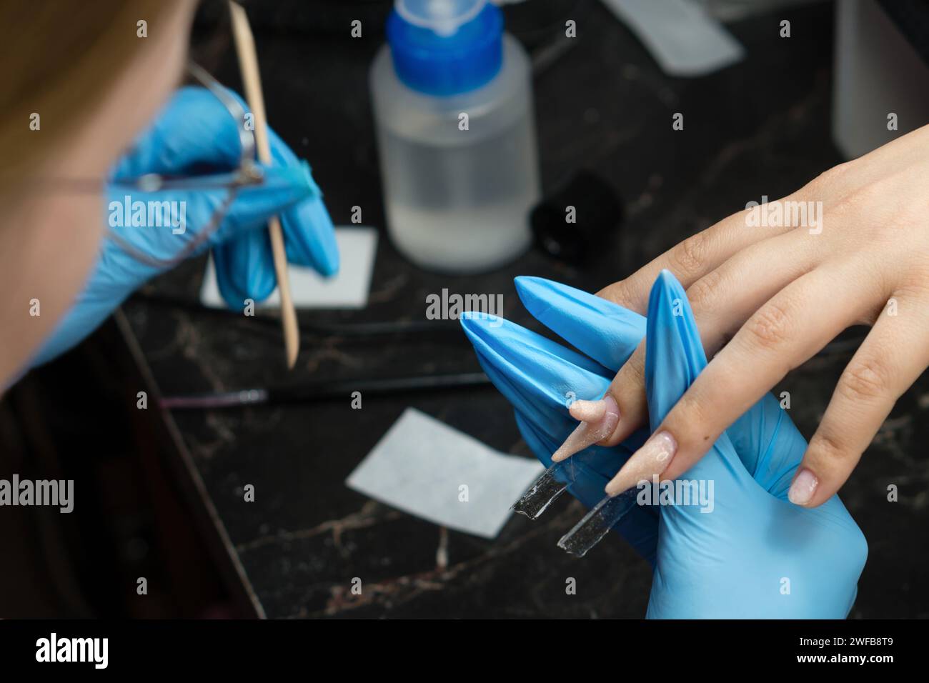 Nail artist lime les ongles de bord pour une forme parfaite dans une séance de manucure. Banque D'Images