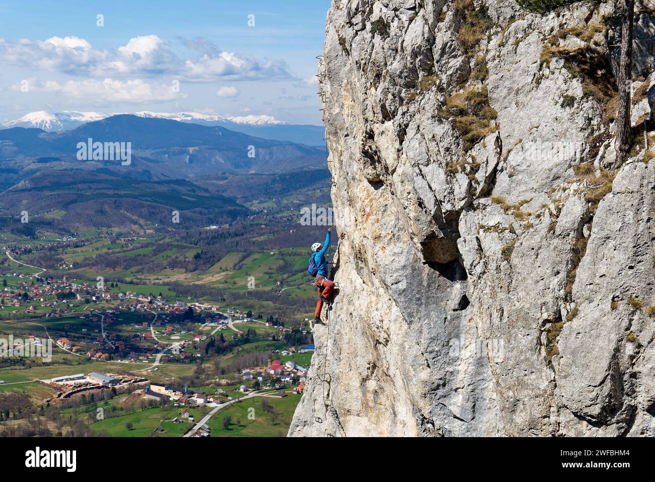 Une personne grimpant sur un itinéraire via ferrata sur un mur vertical de roche. La vie sportive en montagne. Vie active. Grimpeur utilisant l'équipement approprié pour la sécurité. Banque D'Images