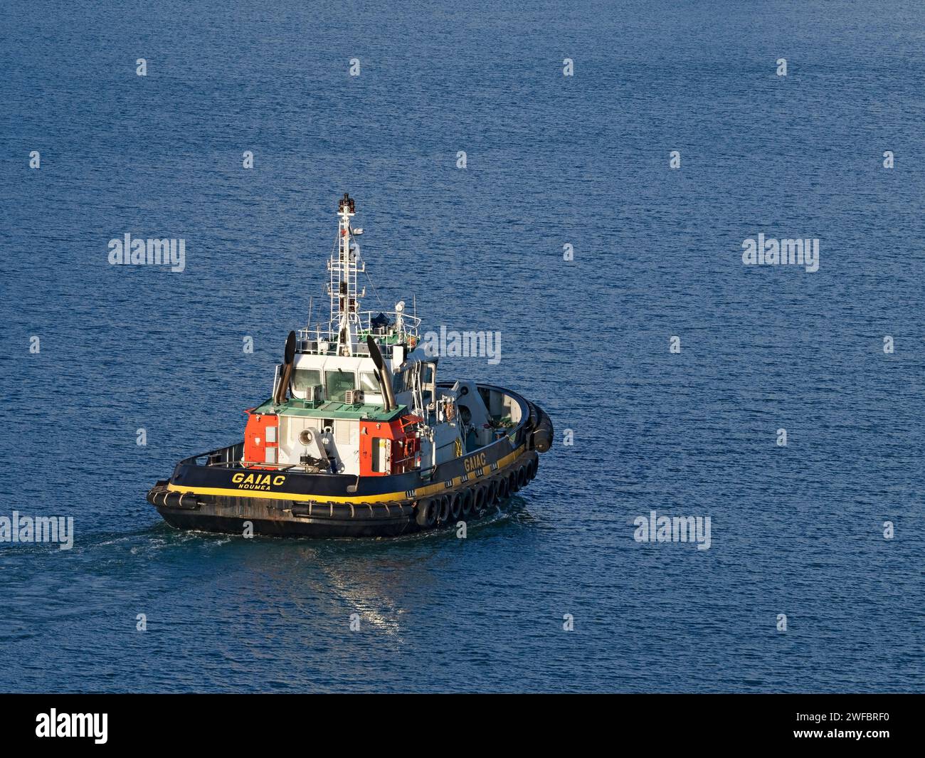 Industrie maritime / le Tugboat Gaiac accompagne un navire de croisière dans le port de Nouméa, en Nouvelle-Calédonie. Banque D'Images