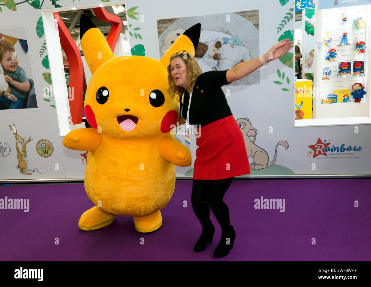 Costume de personnage Pikachu Pokémon, posant avec un gardien, à la foire du jouet 2024, Olympia, Londres Banque D'Images