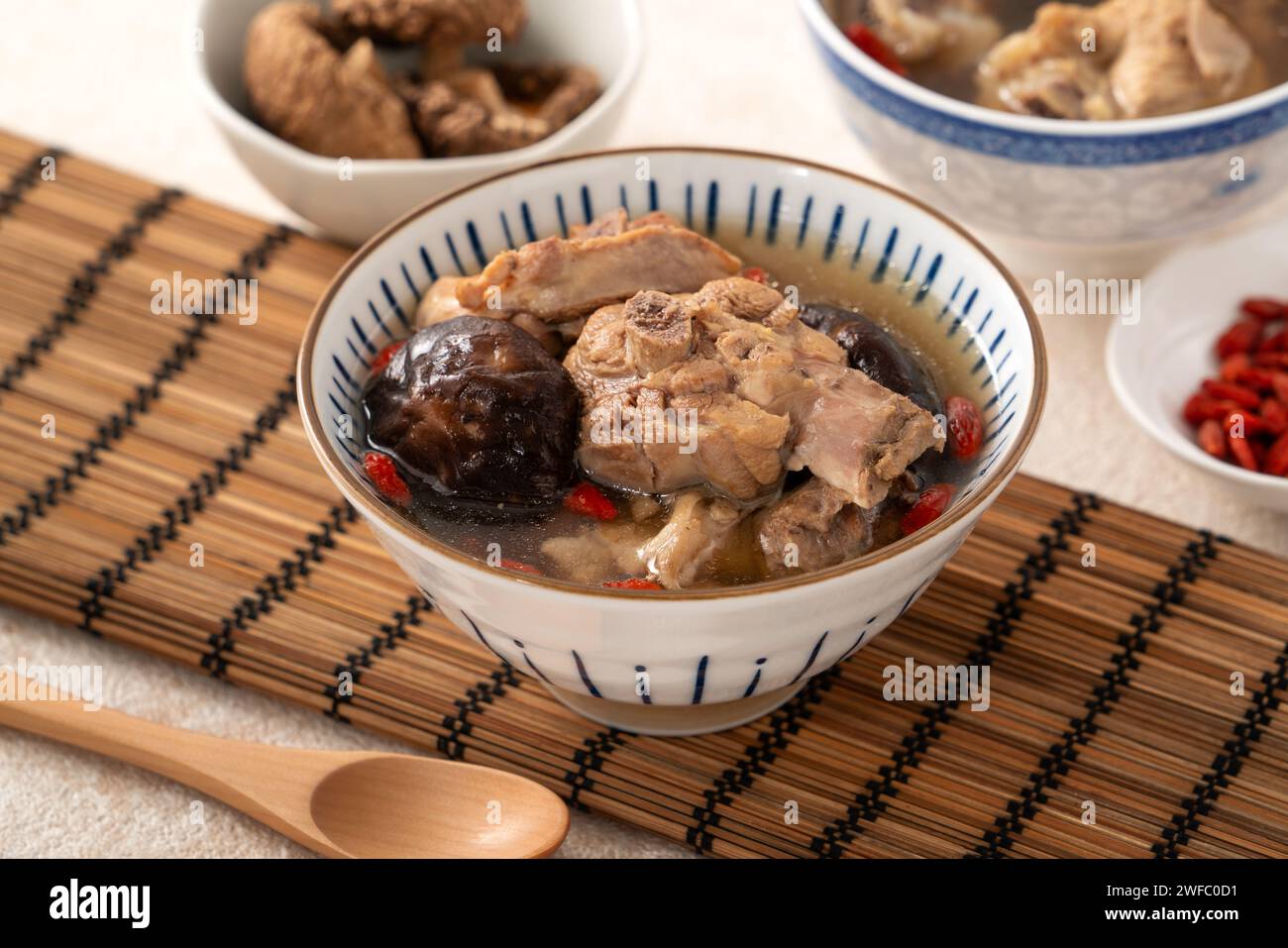 Délicieuse soupe de poulet aux champignons shiitake take taïwanais dans un bol sur fond de table blanc. Banque D'Images