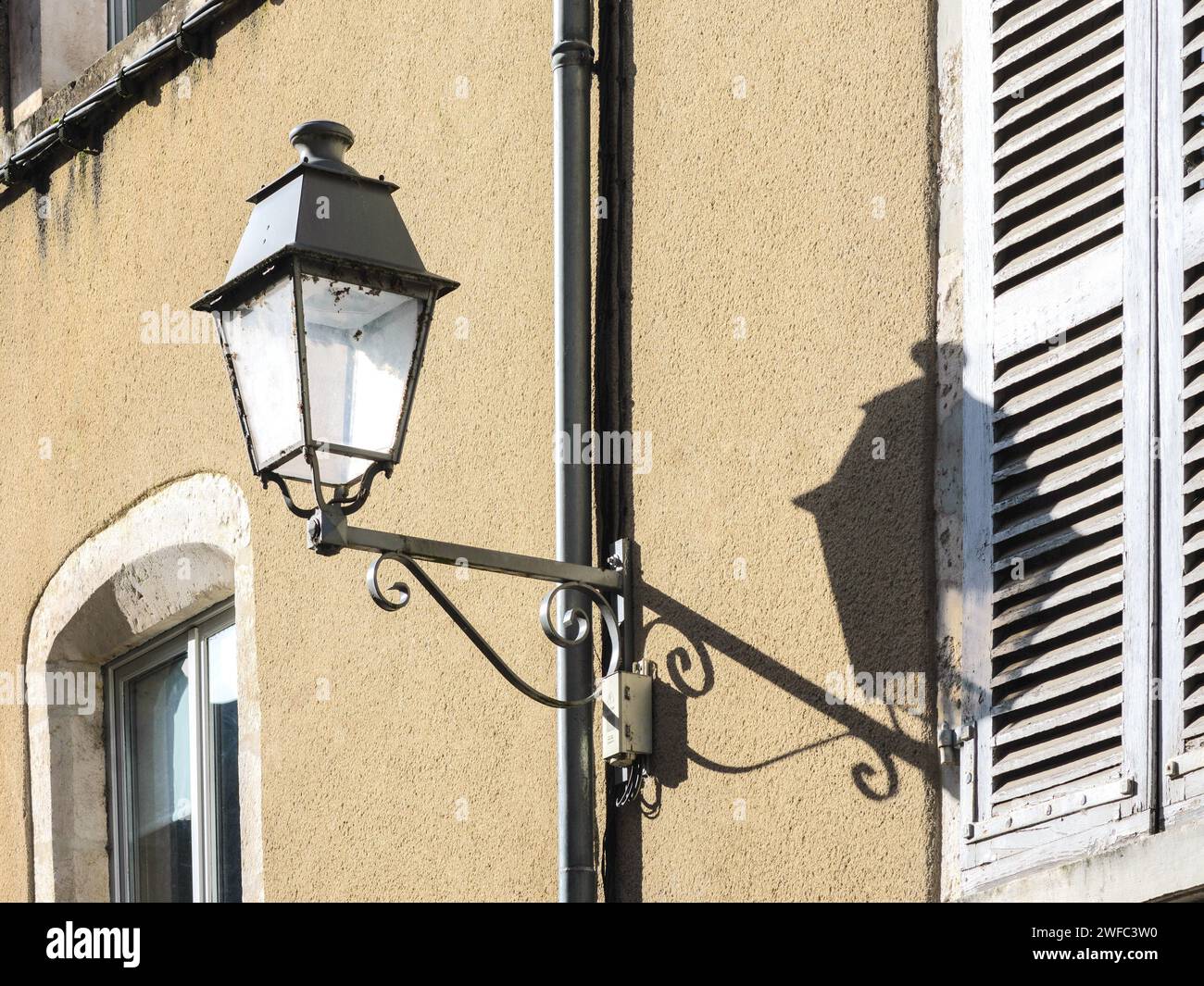 Lumière et ombre - lampadaire avec ombre sur le mur de la maison - le blanc, Indre (36), France. Banque D'Images