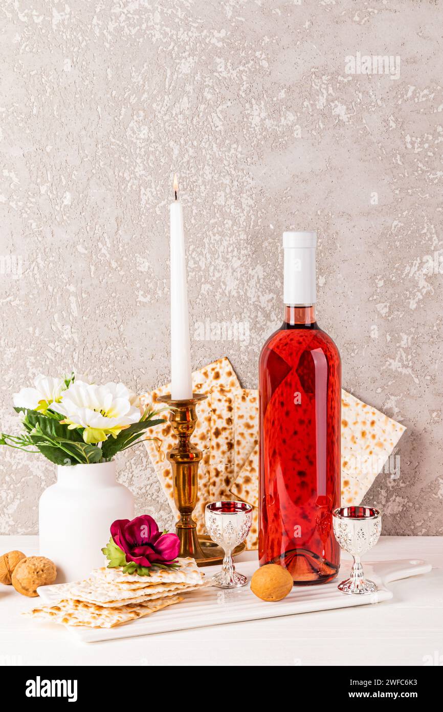 Le concept de Pâque juive. Cuisine kasher traditionnelle pour les vacances, fleurs dans un vase. Une bougie allumée dans un chandelier. Vue verticale Banque D'Images