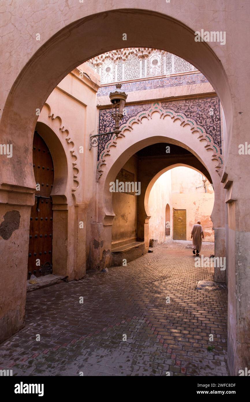 Afrique du Nord Maroc Marrakech Marrakech Médina arches l'homme marocain dans la rue avec des vêtements habillés traditionnels marchant dans la rue étroite vide Banque D'Images