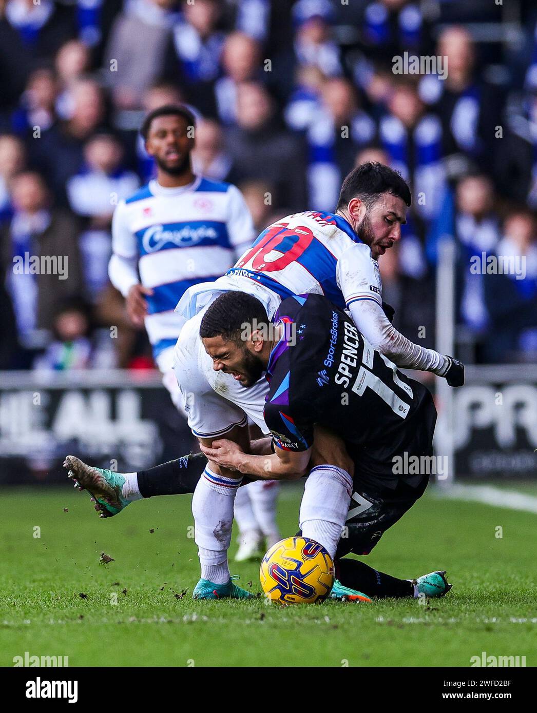 Ilias chair des Queens Park Rangers et Brodie Spencer de Huddersfield Town se battent pour le ballon lors du match de championnat Sky Bet au MATRADE Loftus Road Stadium, Londres. Date de la photo : dimanche 28 janvier 2024. Banque D'Images