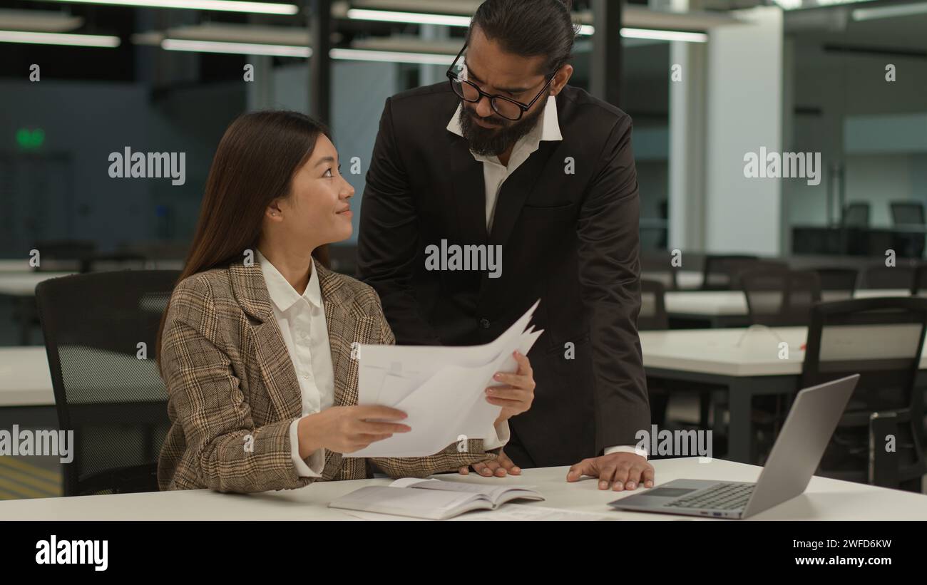 Femme d'affaires asiatique travailleuse coréenne femme gestionnaire femme tri tenant des papiers document paperasse homme d'affaires arabe dirigeant indien PDG mentor Walk Banque D'Images