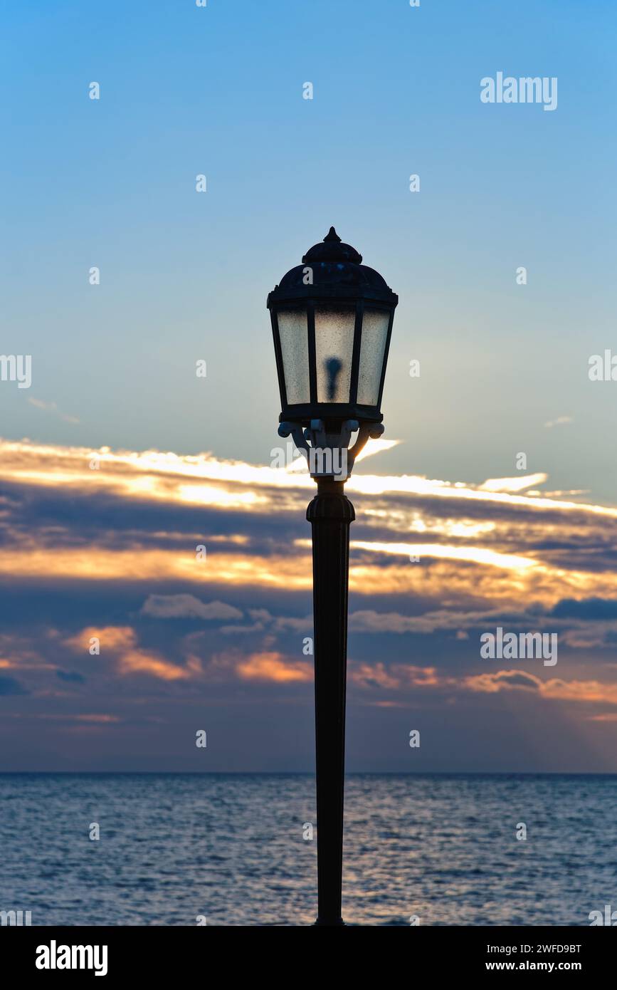 Gros plan d'un vieux lampadaire orné contre un coucher de soleil hivernal au crépuscule Banque D'Images