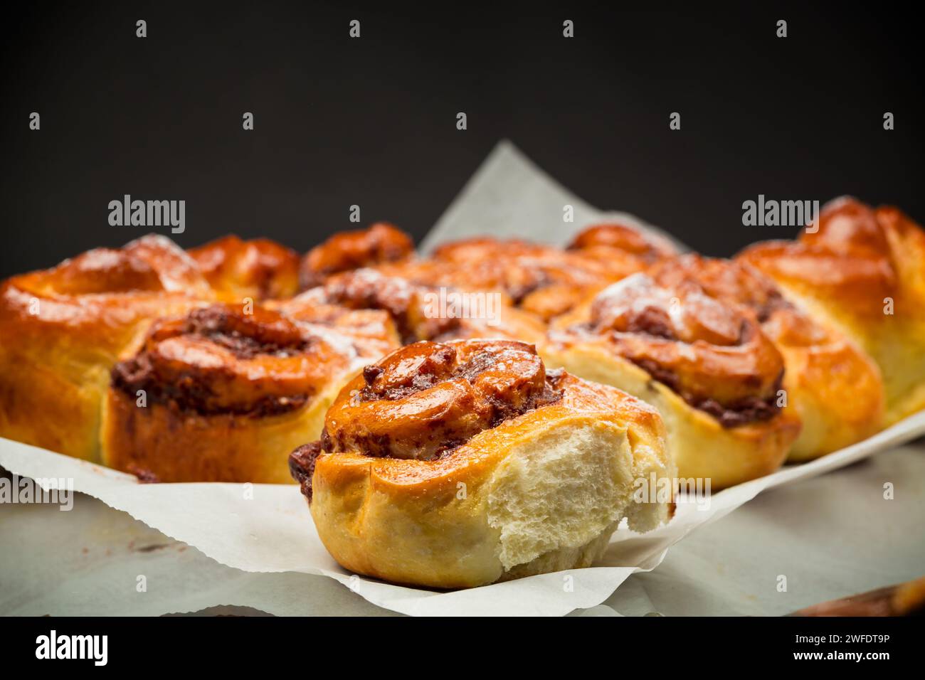 petits pains sucrés cuits au four avec garniture au chocolat, isolés sur fond noir Banque D'Images